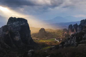 Sunset light breaking through clouds over the Meteora rock monasteries — Meteora private full day trip from Athens